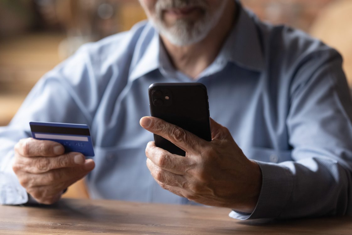 man looking at phone with credit card