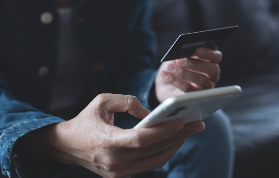 person shopping on smart phone with credit card in hand