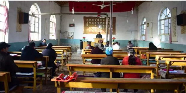A rural church holds a service attended by few people. 